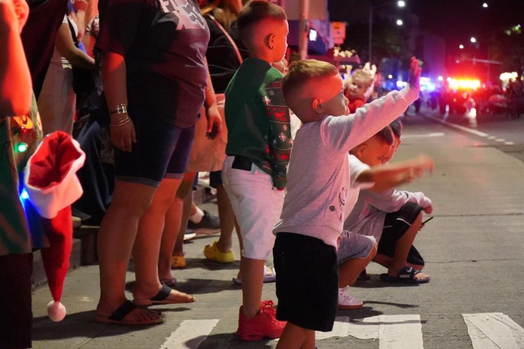 Children wave along the Public Worker's Electric Light Parade during Honolulu City Lights